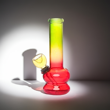 Glass smoking device with a gradient color from red to yellow on a dark background