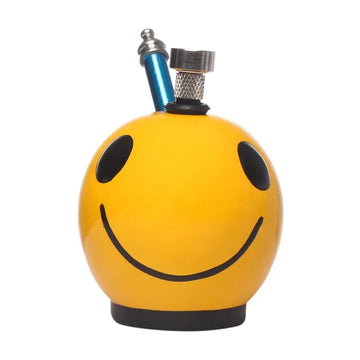 A yellow ceramic water bong with a smiley face design on it, featuring a grip handle and a thumb carb.