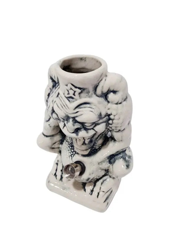 A ceramic water bong in the shape of a devil with a star on its head.