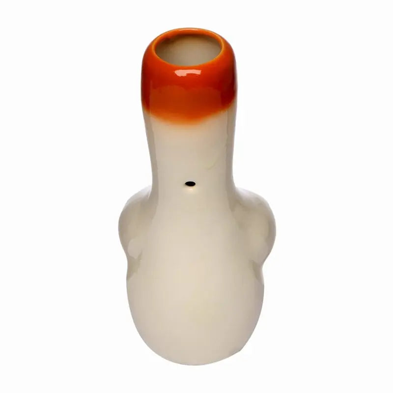 A ceramic water pipe with a female breast design, predominantly white with orange accents, and a rounded body.