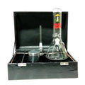 Moksha glass ice bong with mushroom print, along with a metal herb storage grinder, displayed in a black box.