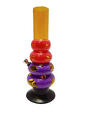 A colorful acrylic water bong with multiple bulbous sections in red, yellow, and purple, standing upright.